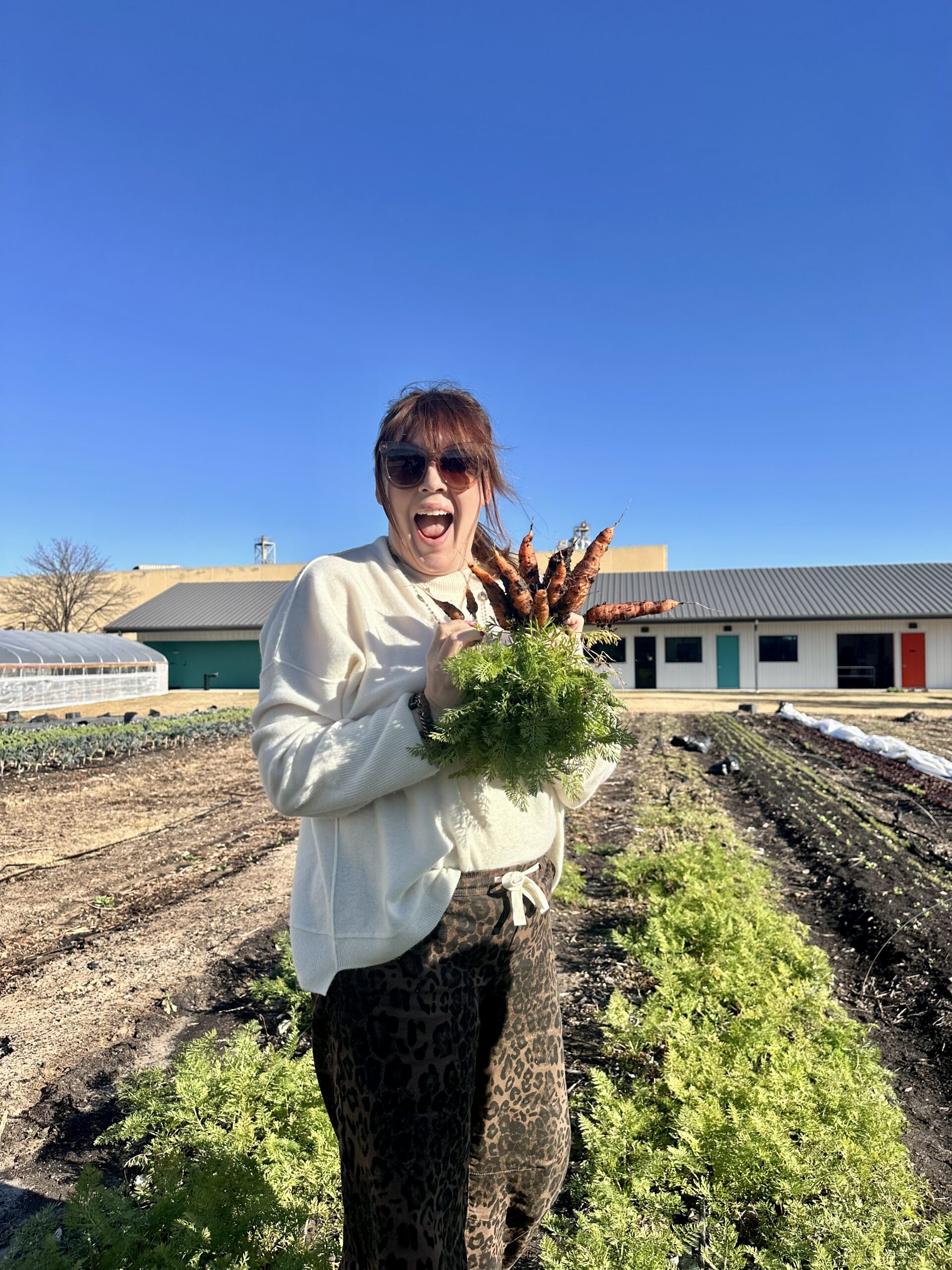Kris Sowell holds carrots harvested at Houston urban farm Finca Tres Robles.